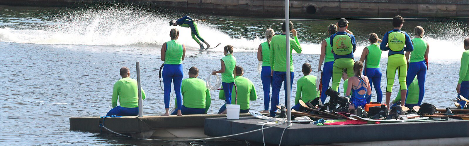 Members of the Tampa Bay Water Ski Show Team watch from the floating dock as they get ready for the next performance at the Tampa Riverfest festival.