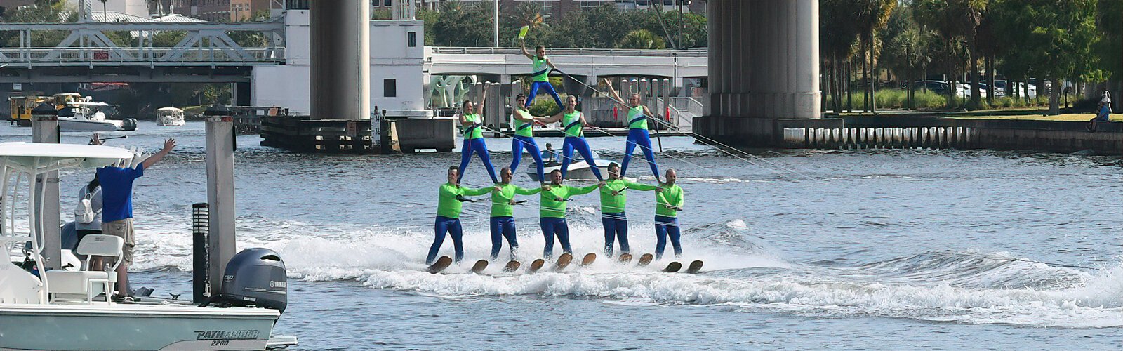 Members of the Tampa Bay Water Ski Show Team form a three-tier pyramid topped by their youngest performer, an eight-year-old girl.