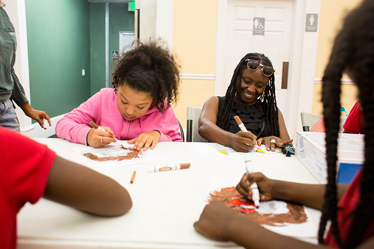 Sonia Coleman works with students in an after-school program at the Tampa Heights Youth Development and Community Center.