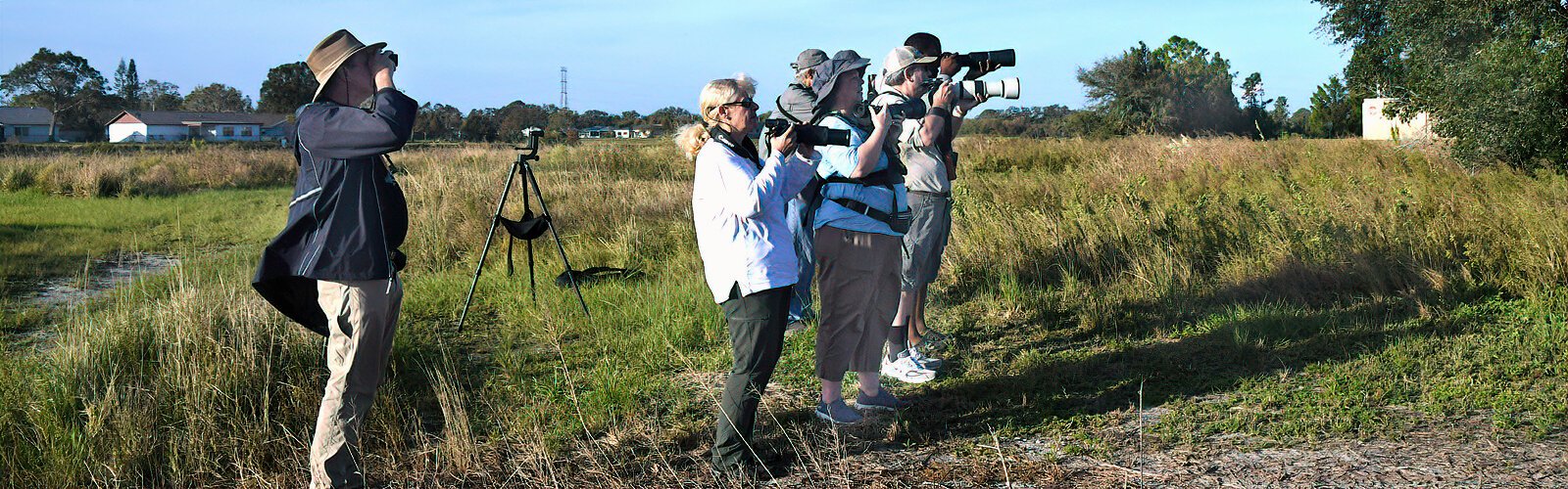 Field trip participants focus their lenses and binoculars on a northern harrier that was briefly spotted in the distance.