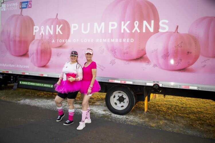 Best friends Charyl Rivera and Brenda Vargas stand together after writing personal messages of gratitude and hope on the Pink Pumpkins truck.