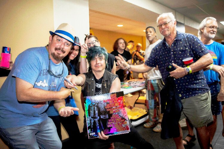 The Dollyrots guitarist and backup vocalist Luis Cabezas signs autographs at WMNF's Tropical Heatwave celebration at the Cuban Club in Ybor City.