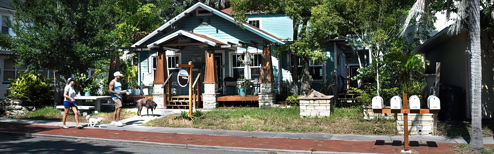  Walking their dogs, two residents stroll by working artists’ studio Francie’s Studio Fifth Avenue in Safety Harbor.