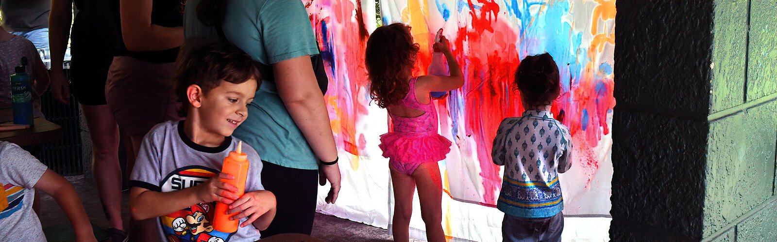 Eloise, 4, gives way to her creativity as she adds her touch to spray-painted sheets during the Rooted in Play adventure event.