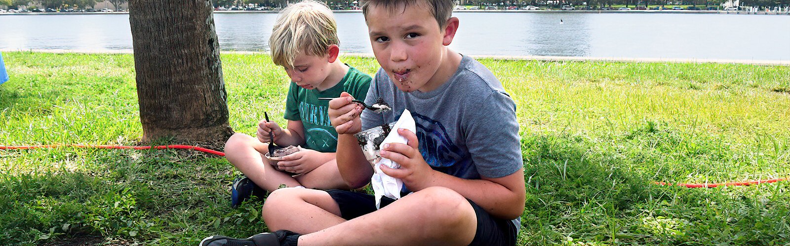 Finding relief from the scorching heat under a palm tree, Finn, 5, and Leo, 7, refresh themselves with some delicious ice cream.