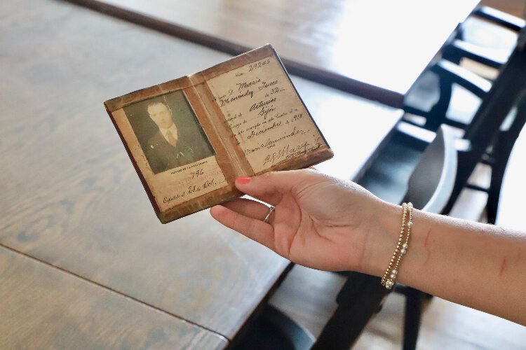 Centro Asturiano is filled with artifacts, many over a century old. Here, Ansley Blackwell holds an original membership booklet dated 1932.