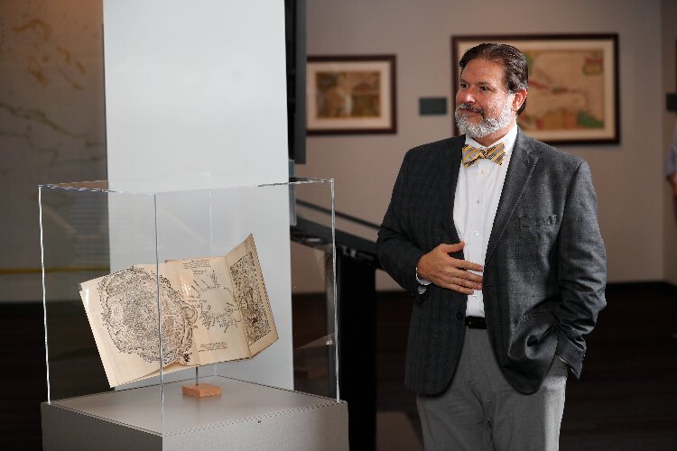 Tampa Bay History Center Touchton Map Library Director Rodney Kite-Powell with the 1524 map of the Gulf of Mexico showcased in the "Mapping the American Sea" exhibit.