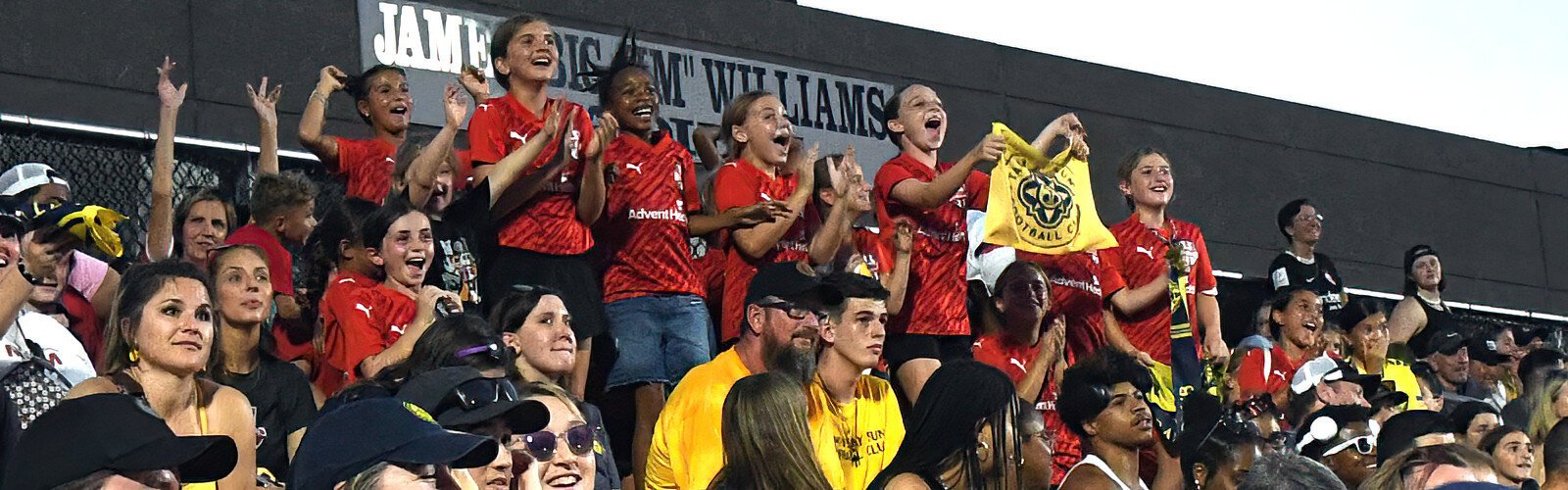 Young female soccer players from Tampa Dynamo FC shout in excitement as Sun FC goalkeeper makes a save.