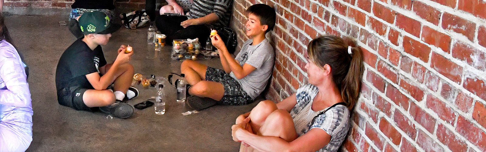 Friends Sawyer and Bryan, 11, find a cool spot to enjoy some cupcakes under the loving eye of Bryan’s mother.