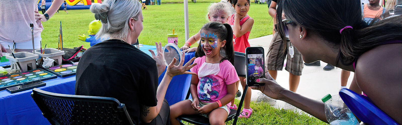 Vienna, 5, gets excited when she looks in the mirror after a stop at The Florida Blue-sponsored face painting booth at the Suncoast Kids Extravaganza.