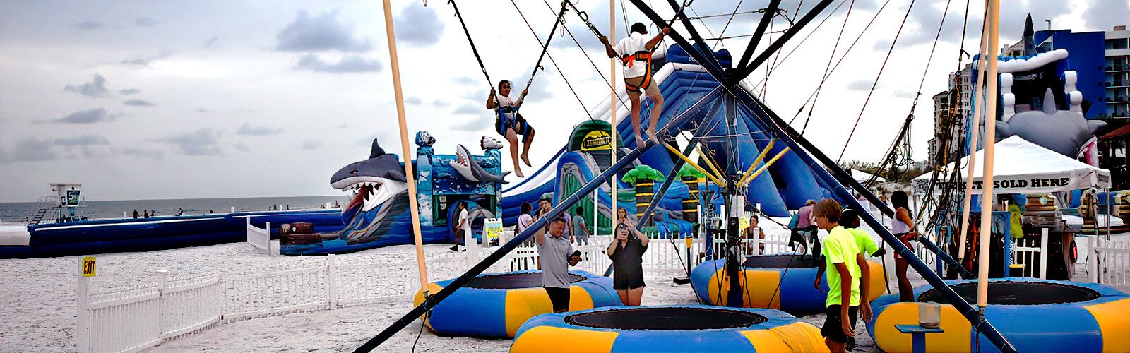 Fun activities on the beach near Pier 60 include a bungee trampoline and giant inflatable waterslide.