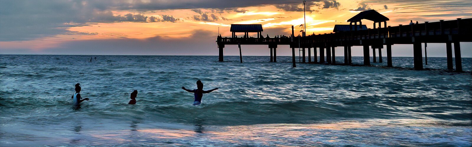 Young beachgoers enjoy the waves as the sun sets at Clearwater Beach.