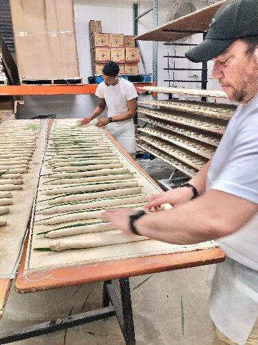 La Segunda's Rodo Ortiz and Terrick Ransom place palmetto leaves on the loaves to score the bread.