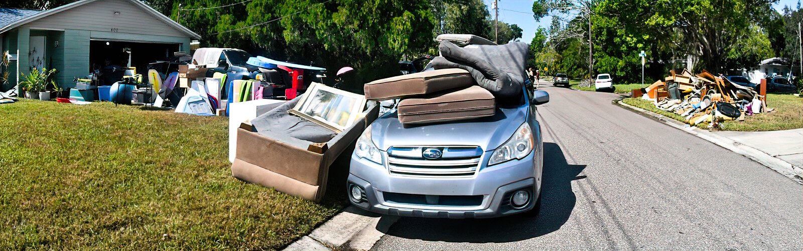 Damaged items from a flooded home are piled up on the front yard all the way to the car in Shore Acres neighborhood.