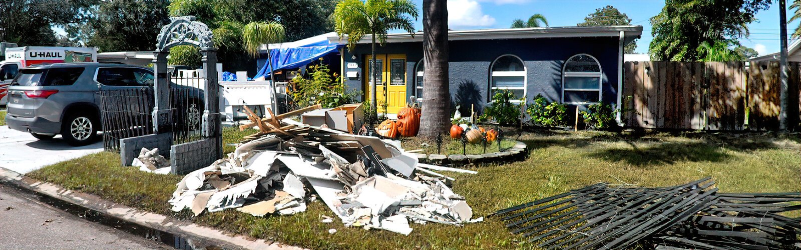 Damaged items from the Shore Acres hurricane flooding are piled up by the curb.