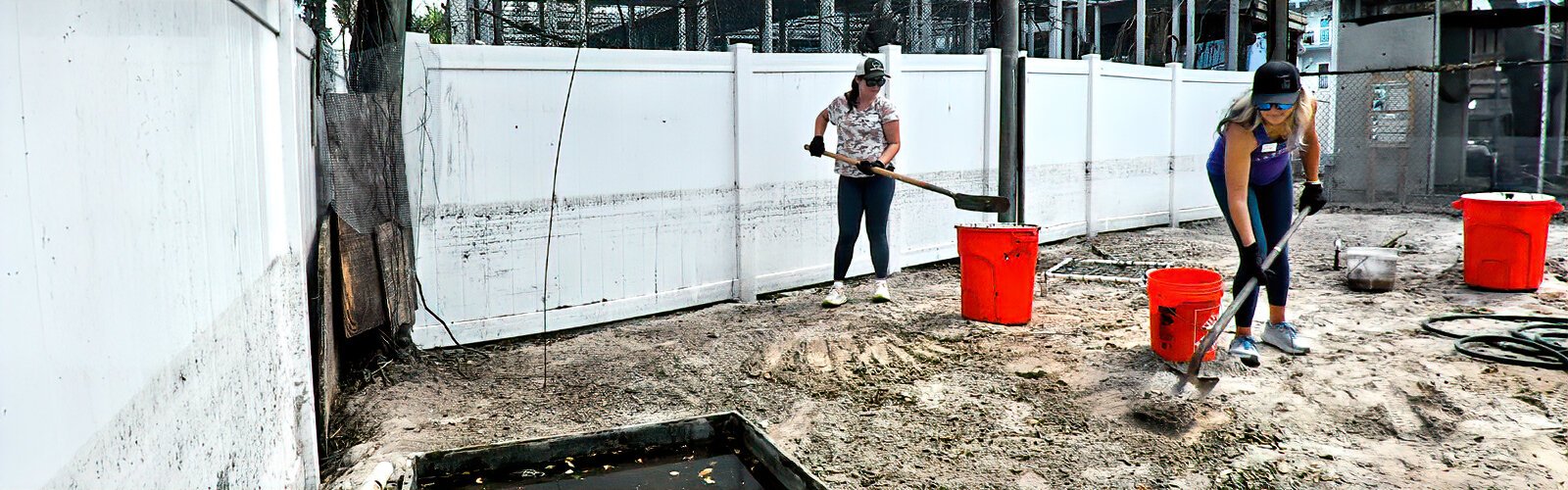 The signs of the storm surge that flooded the Seaside Seabird Sanctuary remain visible on the aviary white fence as volunteers are hard at work in spite of the heat.