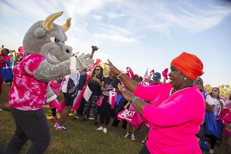 Children With a Vision's Tonya Lewis, faced with cancer in 2024, dances with University of South Florida's Rocky the Bull at Making Strides Against Breast Cancer walk at Raymond James Stadium.