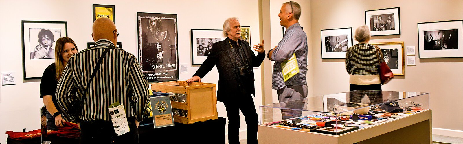 Photojournalist Jay Nolan meets with guests at the opening reception of his photo exhibit “Fandom: Celebrating Rock & Roll with Jay Nolan and Davy Alder” at the Florida Museum of Photographic Arts.