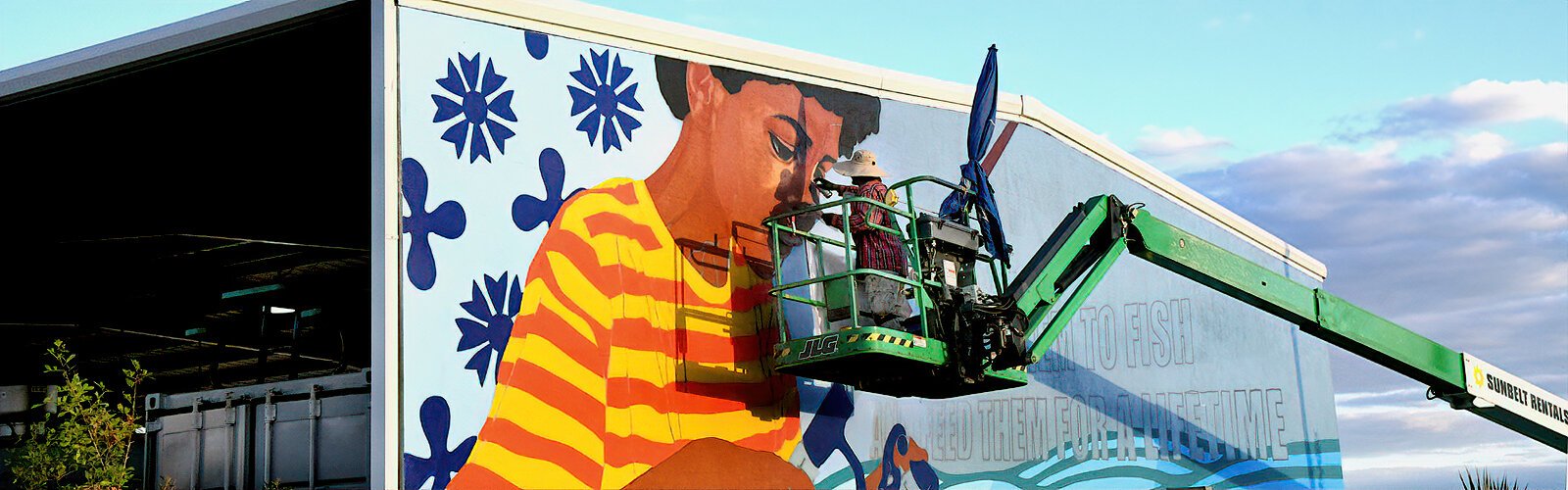 Local artist Zulu Painter works on his SHINE Bright Spot mural “Life Lessons” at AMIKids, a nonprofit organization empowering young people to discover their true potential.