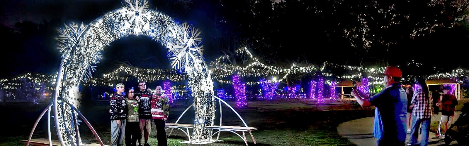  Families take photos under a magnificent snowflake light display at the Holiday Lights in Largo Central Park 