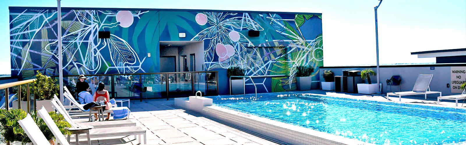 The rooftop pool at the Aloft Hotel is embellished with the “Staycation” mural painted by the Tampa-based duo Illsol.