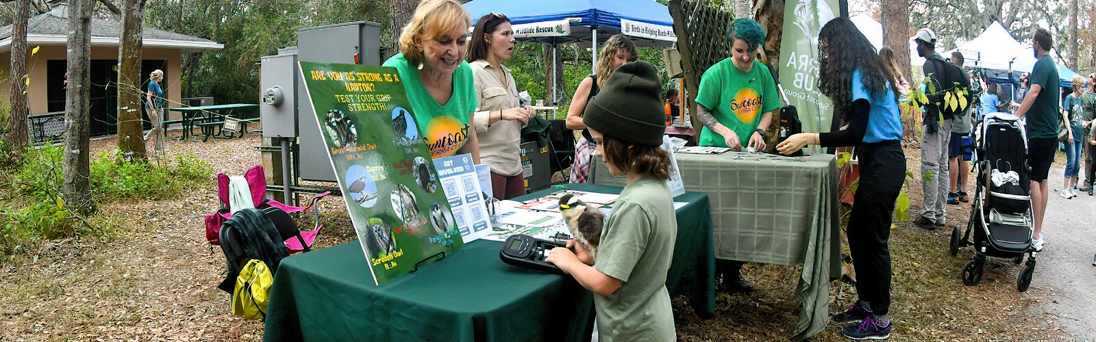 Holding a plush raptor, Rexford, 7, tests the strength of his grip with a hand dynamometer at the Sierra Club Suncoast Group table, and gets a reading for the screech-owl category.