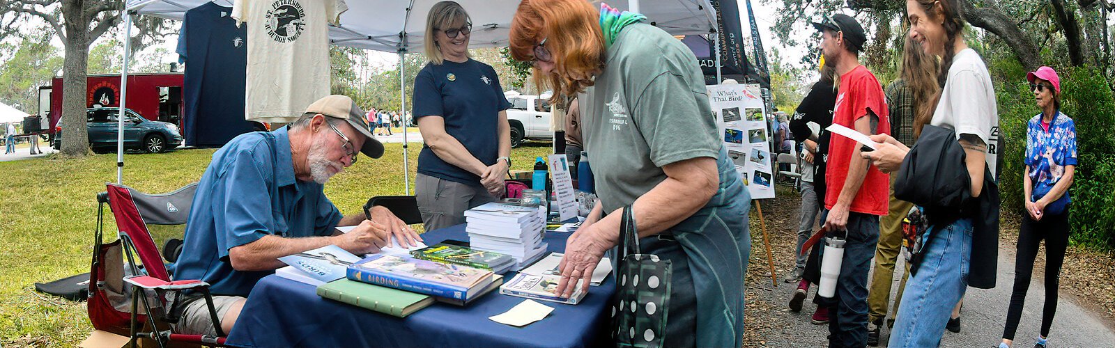 Local author Ron Smith signs his two books “The Birds of Pinellas County” and “The Butterflies of Pinellas County” at the St Petersburg Audubon Society table.