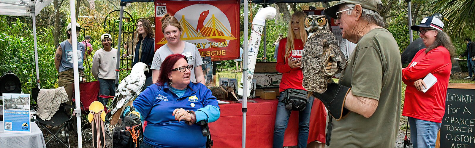  Seaside Seabird Sanctuary volunteer Carol, with a leucistic red-tailed hawk Oden, chats with Friends of Largo Nature Parks’ Will, who has great-horned owl Franklin, and with the Skyway Team Rescue. 