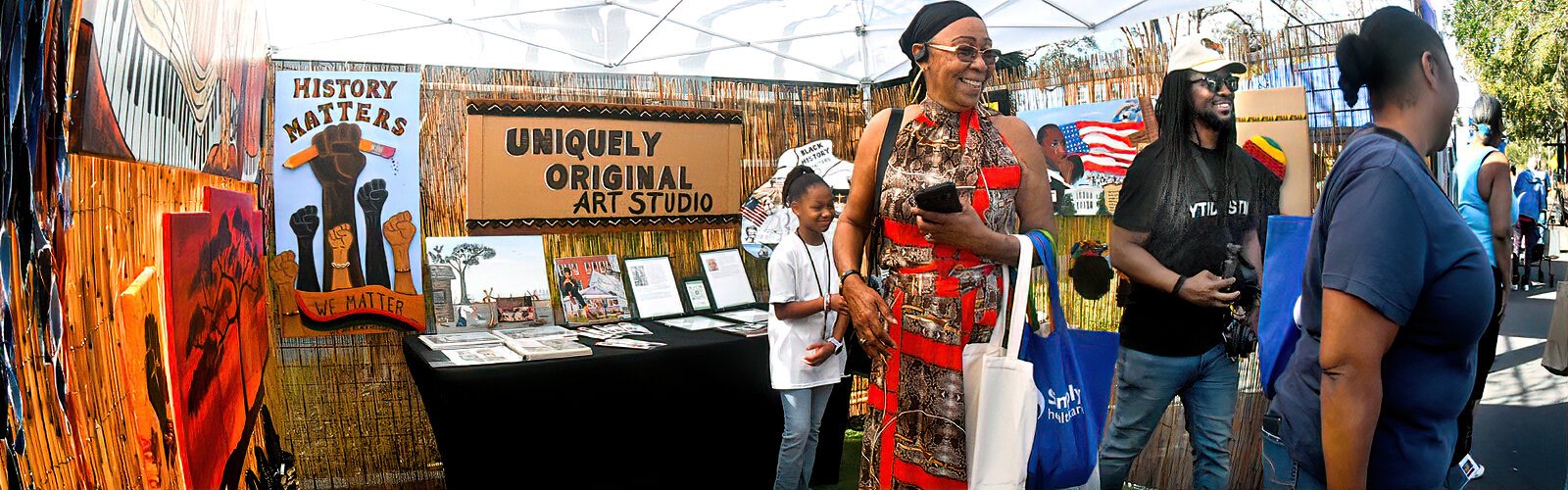 Festival attendees visit the Uniquely Original Art Studio booth of entrepreneur-artist Catherine Weaver, a St Petersburg native dedicated to uplifting her community.