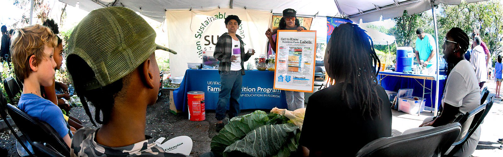 With the help of a young volunteer from the audience, Renee of the Family Nutrition Program explains how many spoons of sugar soda drinks contain and how to make healthier choices.