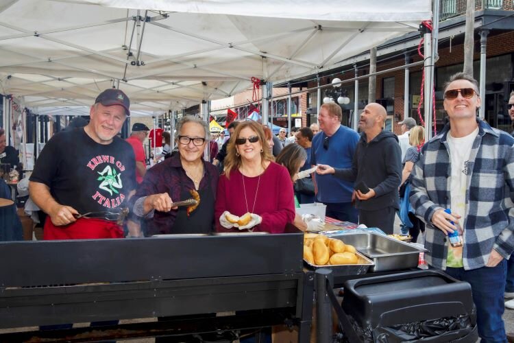 Italian Club of Tampa members Joe DiNicola, Vince Pardo, and Doreen Greco prepare Italian sausage as Damon Shiver looks on during the  78th Ybor Fiesta Day celebration. 