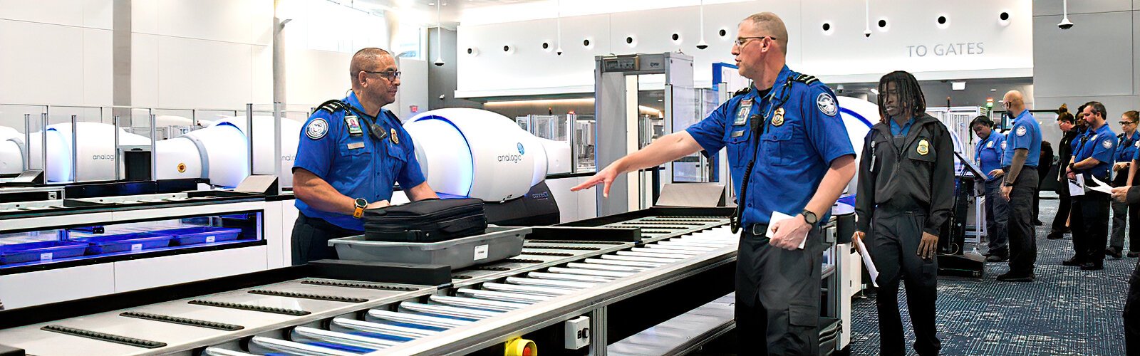 Transportation Safety Administration (TSA) agents go through training for the Computed Tomography (CT) X-ray system in the new Airside E expanded security checkpoint.