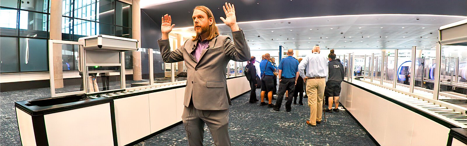 TSA  regional spokesperson Mark Howell demonstrates how passengers currently go through screening with their arms held up, a requirement eliminated in the improved experience with the new AIT process.