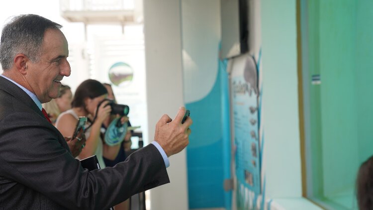 Clearwater Mayor Bruce Rector takes a picture during the event unveiling Clearwater Marine Aquarium's new manatee rehabilitation center.